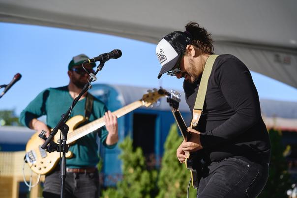 Two men play guitars on stage