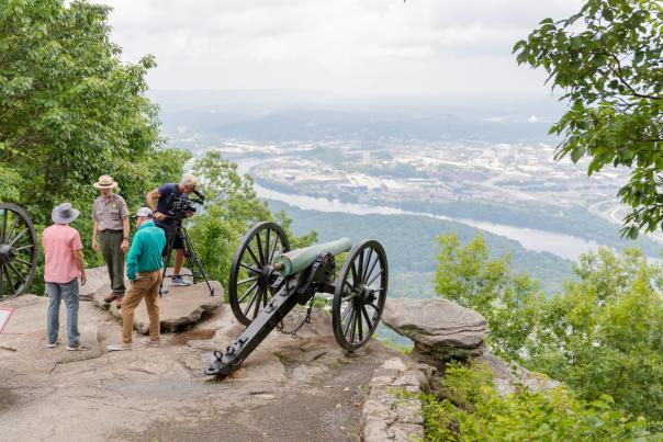 RV There Yet? TV show production at Point Park - TV hosts talk to park ranger at overlook with downtown Chattanooga and river in the background